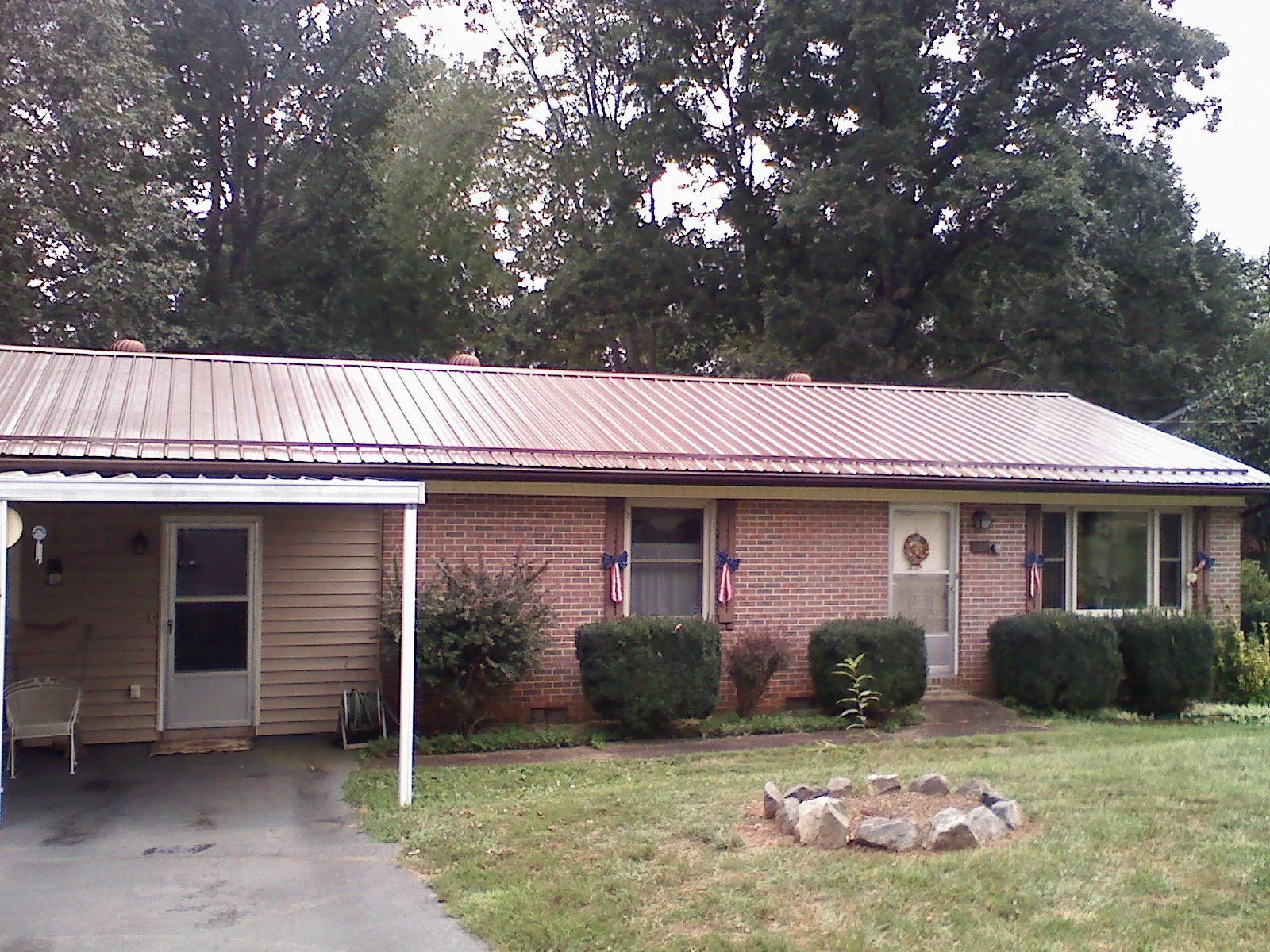Bronze metal roof and carport on a brick ranch home — Roof Repair work by our crew in Acton